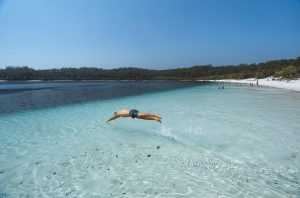 Diving Into Lake McKenzie. Photographed by Reuben Nutt. Image via Tourism and Events Queensland.