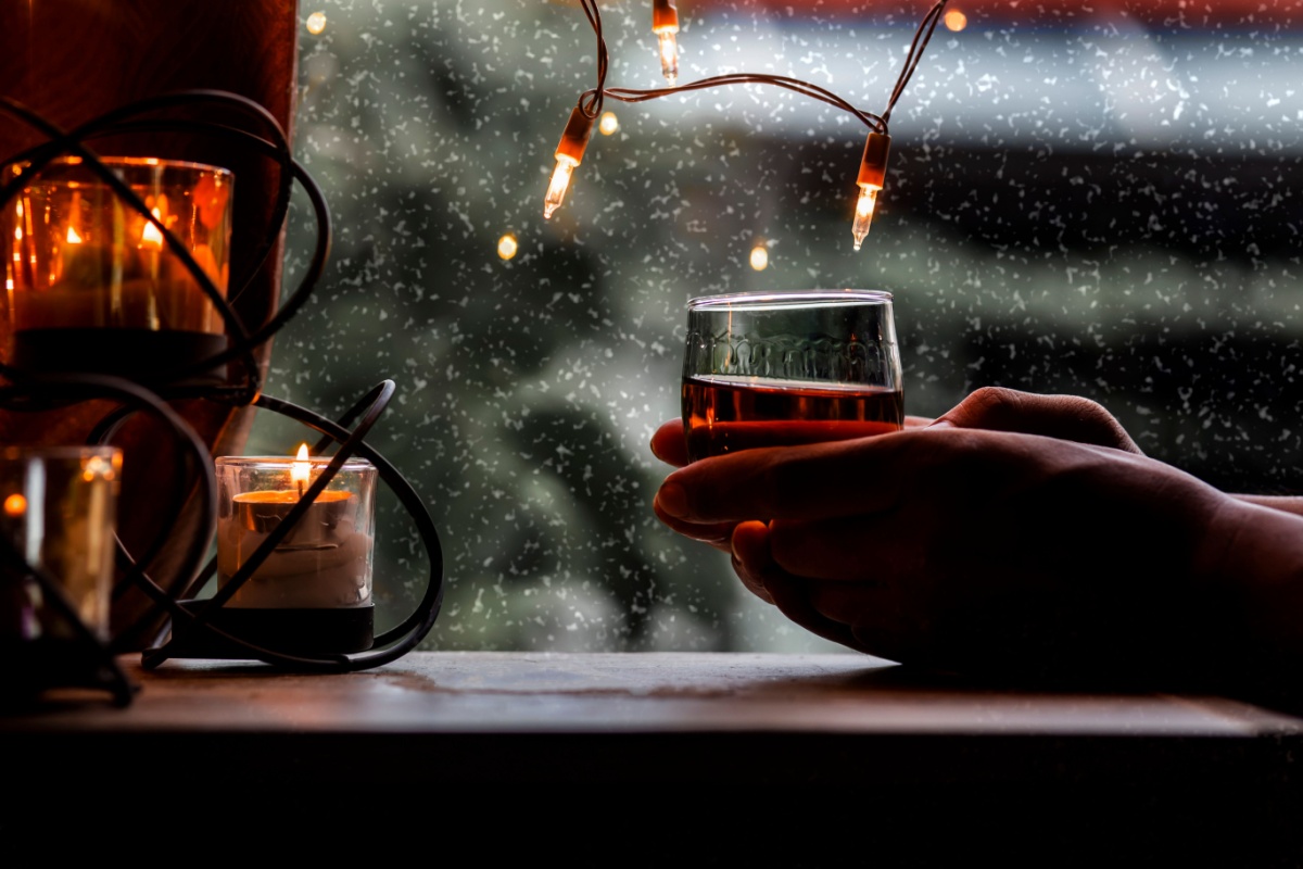 Hands holding whisky in winter. Photography by SOMKID THONGDEE. Image via Shutterstock