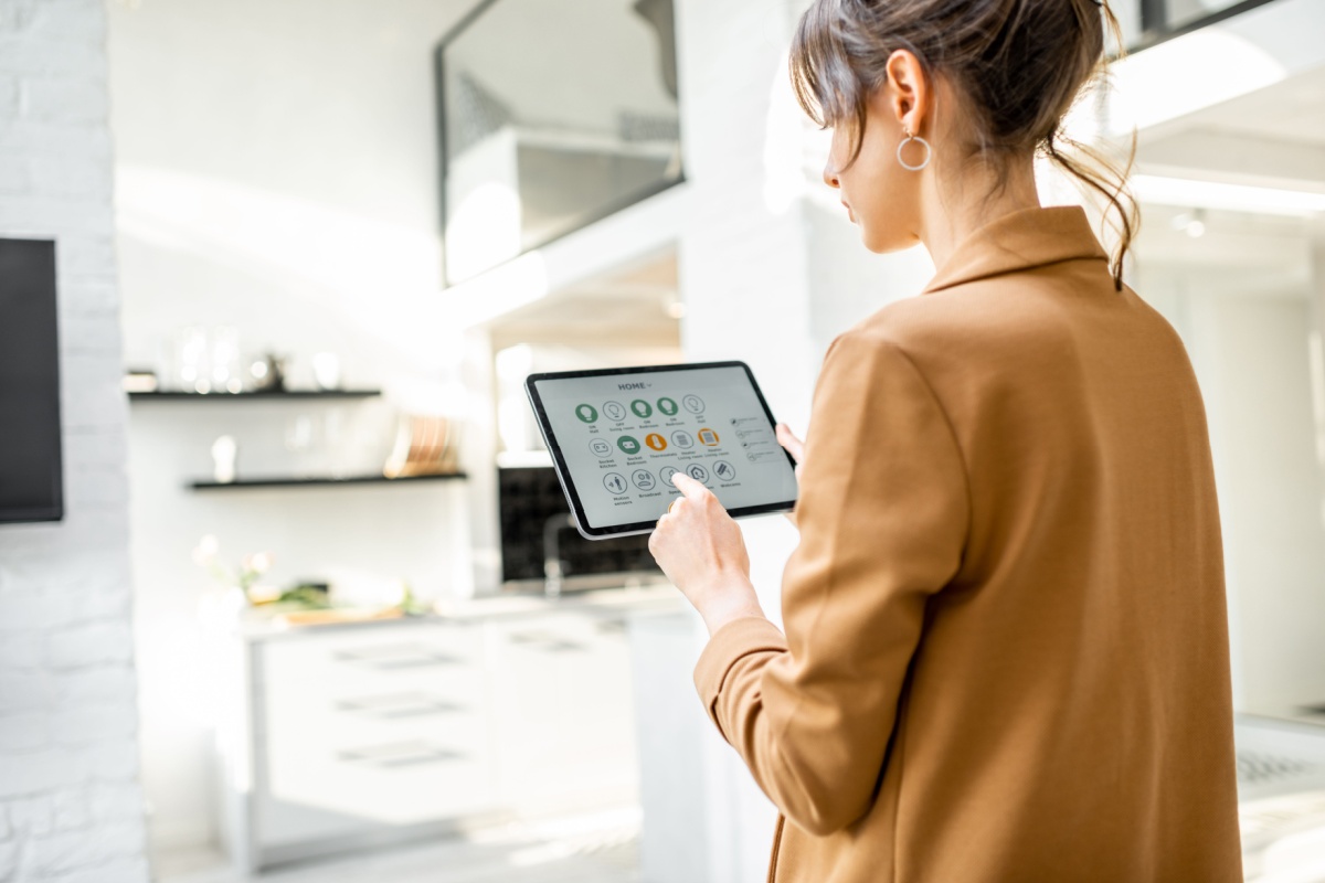 Woman controlling smart home. Photography by RossHelen. Image via Shutterstock