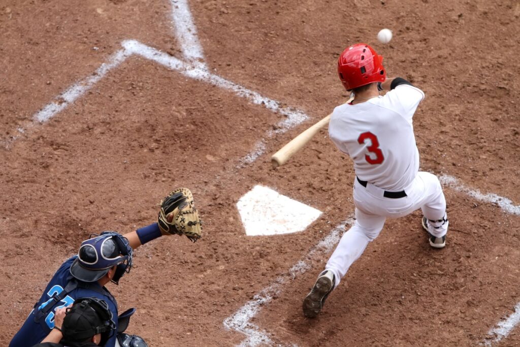 Baseball swing on home plate. Photography by Paul Yates. Image via Shutterstock