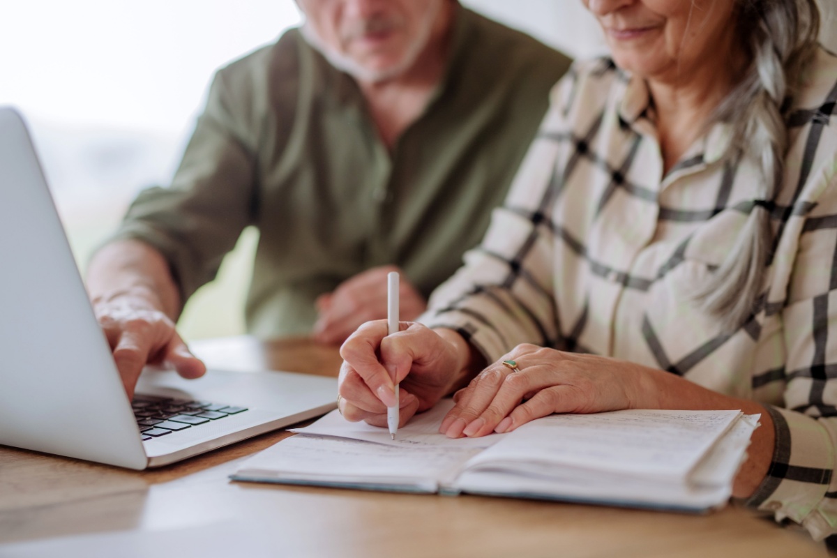 Couple budgeting at home. Photography by Halfpoint. Image via Shutterstock