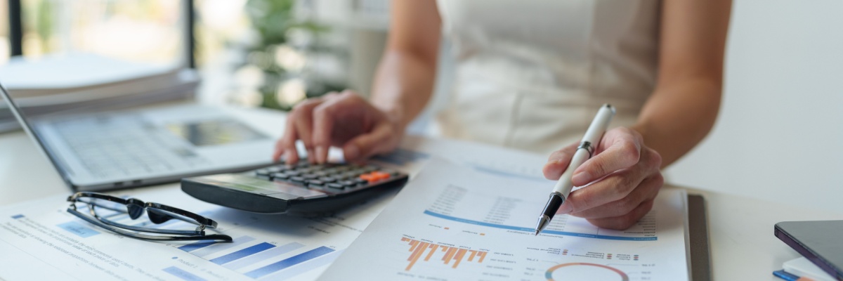 Woman calculating finances. Photography by CrizzyStudio. Image via Shutterstock