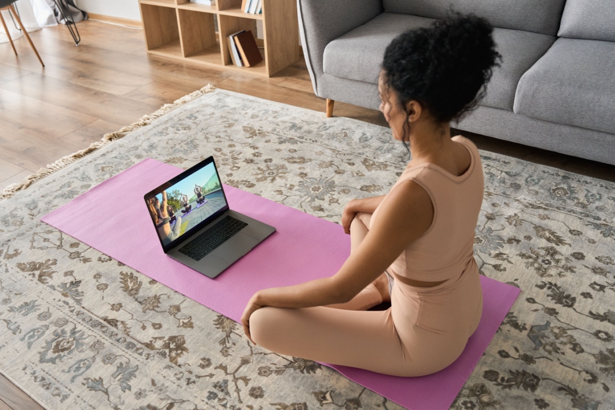 Young woman watching yoga. Photography by Ground Picture. Image via Shutterstock