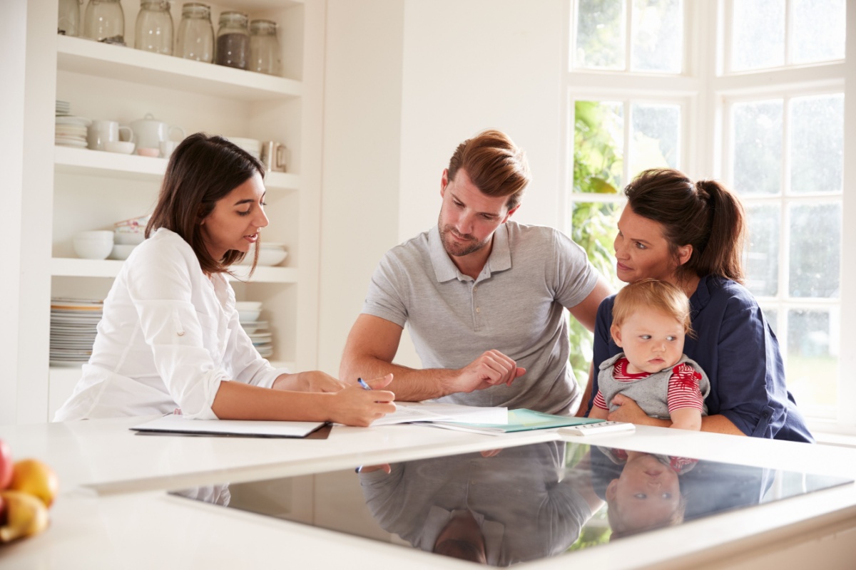 Family looking over contract. Photography by Monkey Business Images via Shutterstock