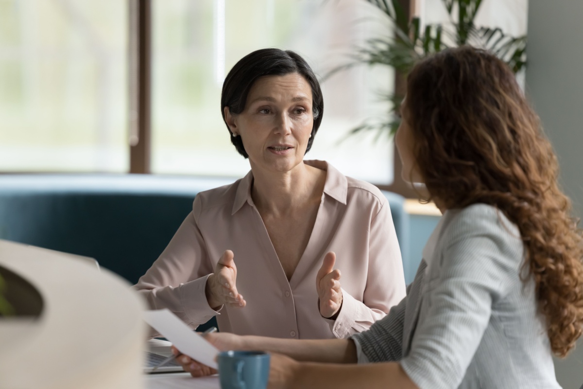 Two women talking. Photography by fizkes via Shutterstock