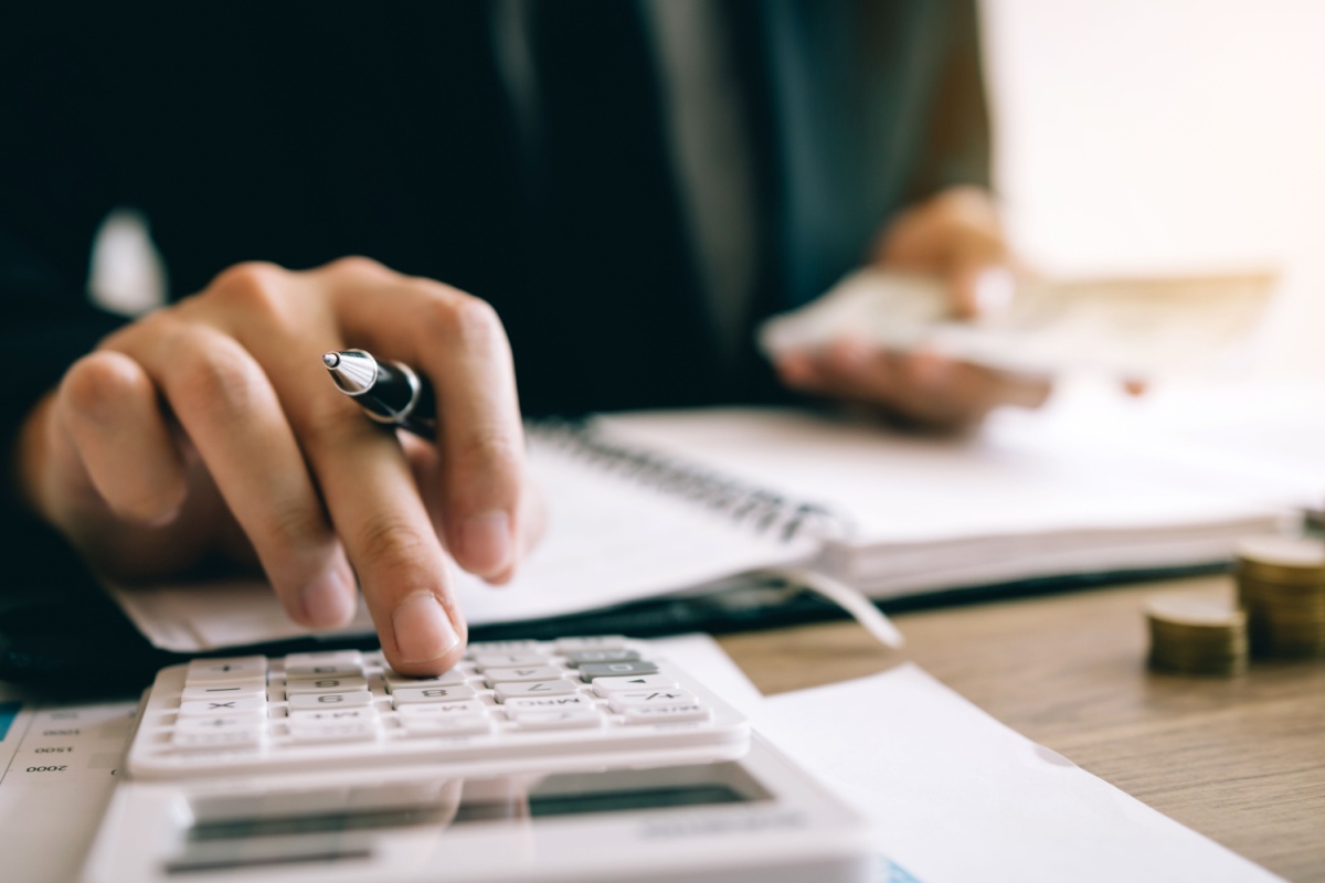 Person on calculator. Photography by wutzkohphoto via Shutterstock