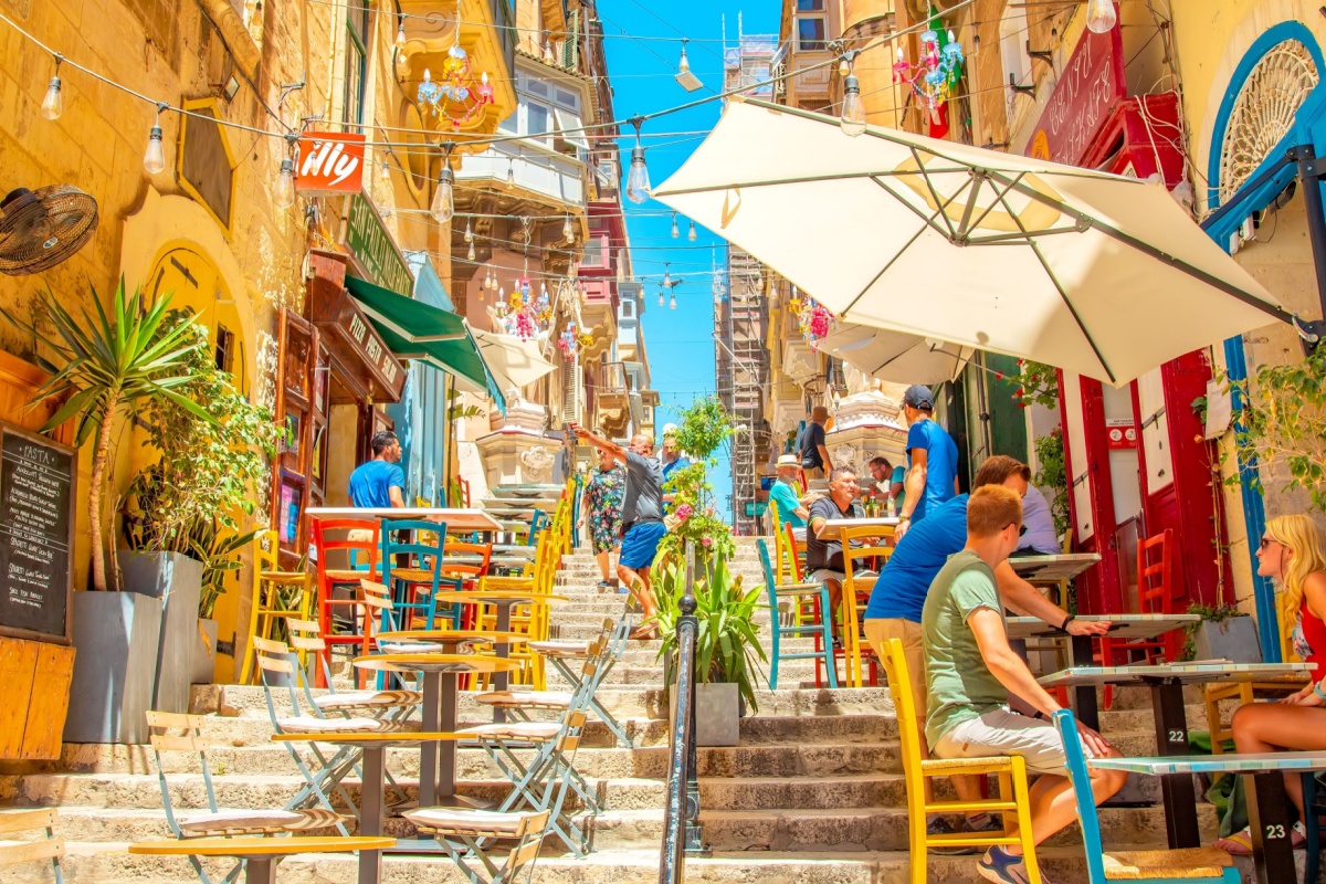 Wide panoramic view of summer street and pavement cafe in Valletta old town. Photography by Arcady via Shutterstock